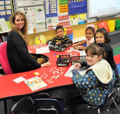 Teacher working with students on math work at kidney table